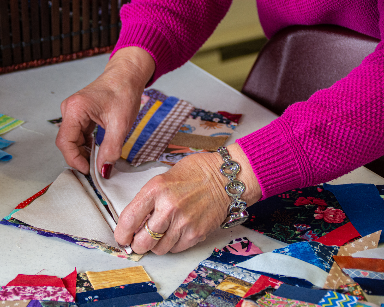 Here Colleen is demonstrating how to fold material to make squares for a crumb quilt.