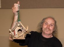 man holding birdhouse