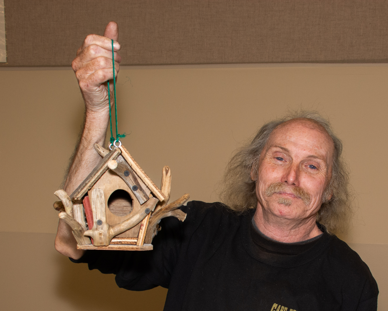 man holding birdhouse