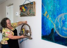 woman hanging art in a gallery