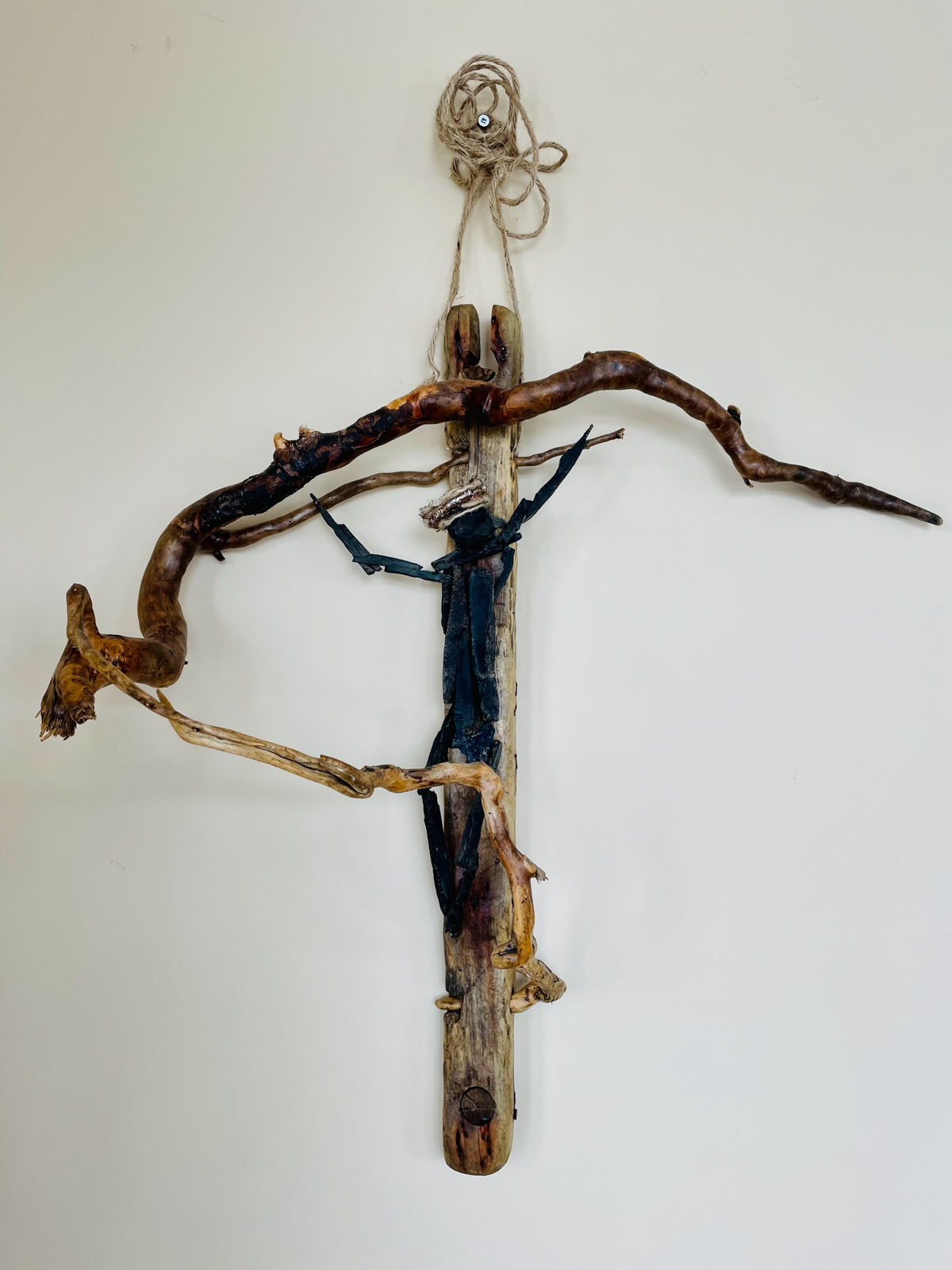 Christ on the Cross — This crucified Christ image evokes the same awe and wonder religious relics might. The figure is made from lobster trap debris, driftwood root, and Grand Greve stone. In religious iconography, the crossbeam represents the person crucified and this one appears to be in motion. The crown of thorns is a circular rhinestone brooch bound in jute and copper fibre. (Photo: Cynthia Curtis)