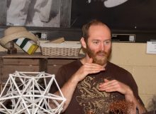 Man in cafe behind a dodecahedron sclupture