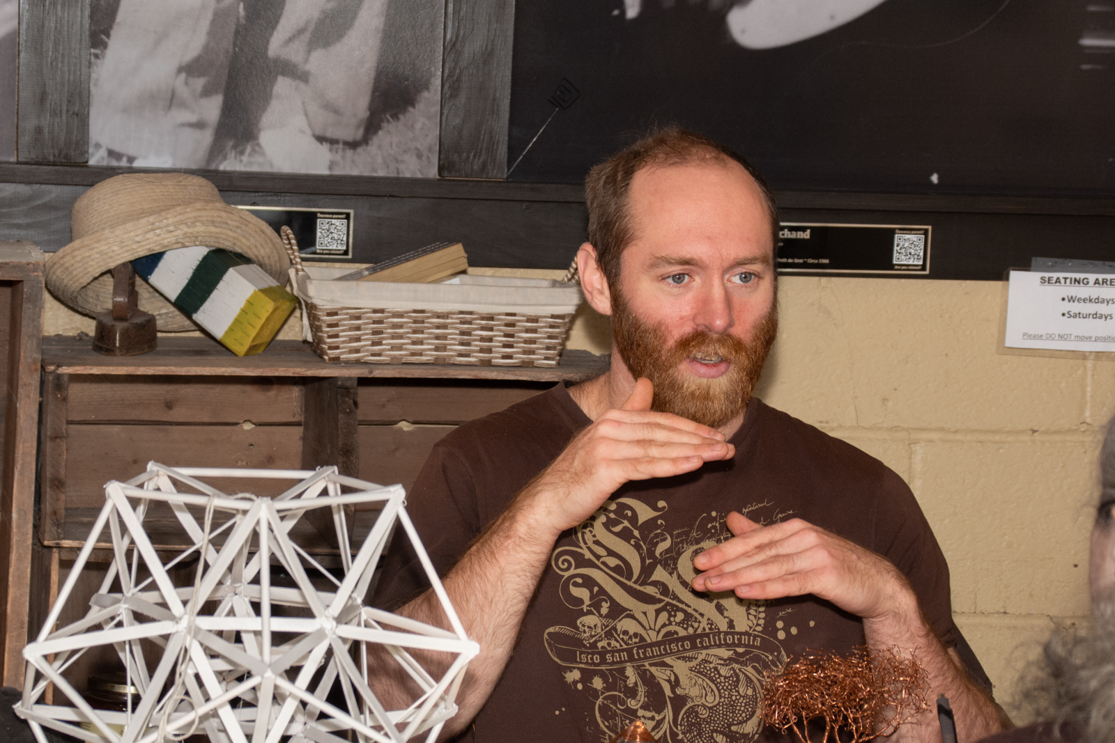Man in cafe behind a dodecahedron sclupture