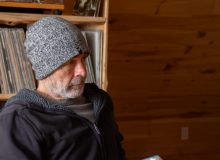 older man with toque in front of record case