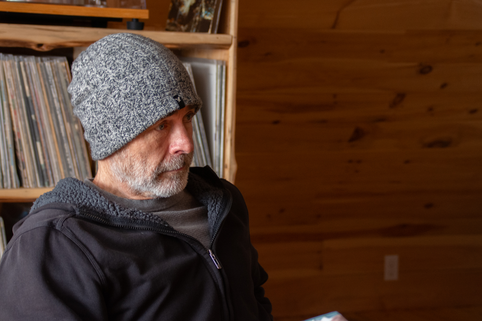 older man with toque in front of record case